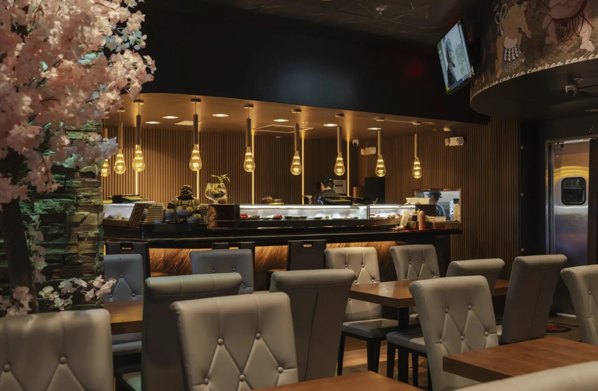 Koi Fort Lauderdale dining room with a curved sushi counter, tufted chairs and a cherry blossom tree